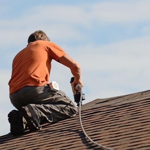 A roofer installs shingles.