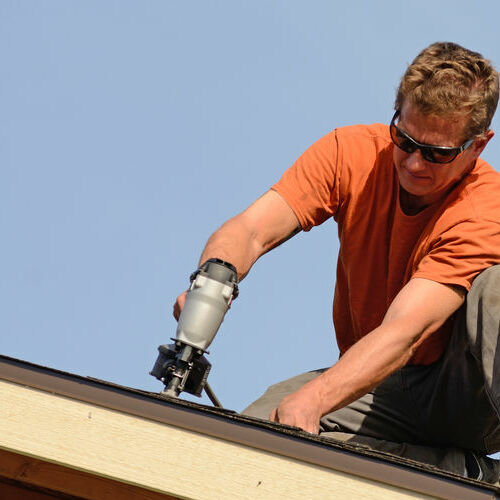 A roofer installs shingles.