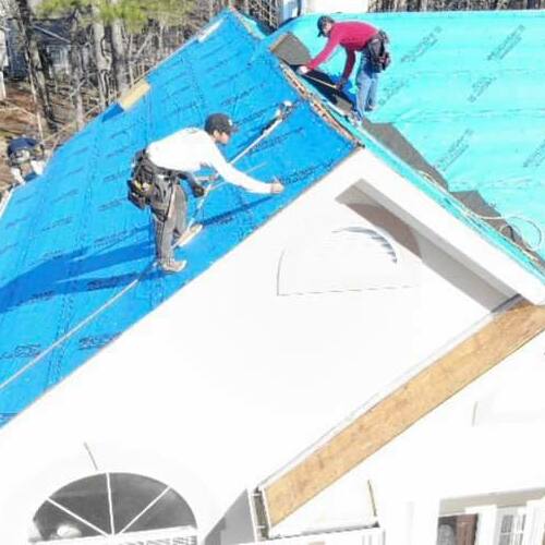 Roofers work on a roof.